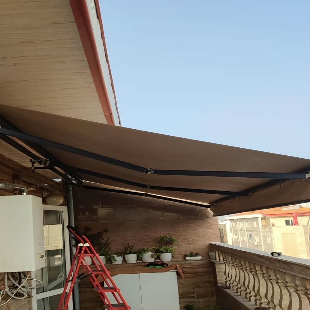 نصب سایبان برقی در ایلام برای یک مغازه لوازم خانگی در خیابان پرتردد شهر با بازدید اولیه، اندازه&zwnj;گیری دقیق دهانه و بررسی جهت تابش آفتاب آغاز شد تا مدل انتخابی پاسخگوی کاربری واقعی باشد. سایبان برقی در ایلام در این پروژه میان سایبان بازویی مدرن و سایبان برقی لوکس مقایسه شد؛ نسخه بازویی برای دهانه متوسط و تردد معمول مناسب بود، اما به دلیل باز و بسته شدن مکرر در طول روز، مدل لوکس با سازه آلومینیومی مهندسی&zwnj;شده و یراق تقویت&zwnj;شده انتخاب شد تا دوام بیشتری ایجاد کند. استفاده از پارچه&zwnj;های باکیفیت اروپایی کمک کرد رنگ سایبان نمای ساختمان در برابر نور شدید تغییر محسوسی نداشته باشد و موتور با حرکت نرم در سیستم کنترل استاندارد، عملکرد یکنواختی ارائه دهد. انتخاب نادرست متریال یا بی&zwnj;توجهی به شرایط محیطی می&zwnj;تواند موجب افت کشش بازوها یا نیاز به سرویس زودهنگام شود. قیمت وابسته به ابعاد، نوع مدل و سطح تجهیزات است و برای اطلاع از قیمت روز باید تماس مستقیم برقرار گردد. برای اجرای دقیق سایبان برقی در ایلام امکان بازدید حضوری، اندازه&zwnj;گیری و ارائه پیشنهاد طرح متناسب با پروژه پیش از ثبت سفارش فراهم است. /p table tr th>عنوان</th th>توضیحات</th /tr tr