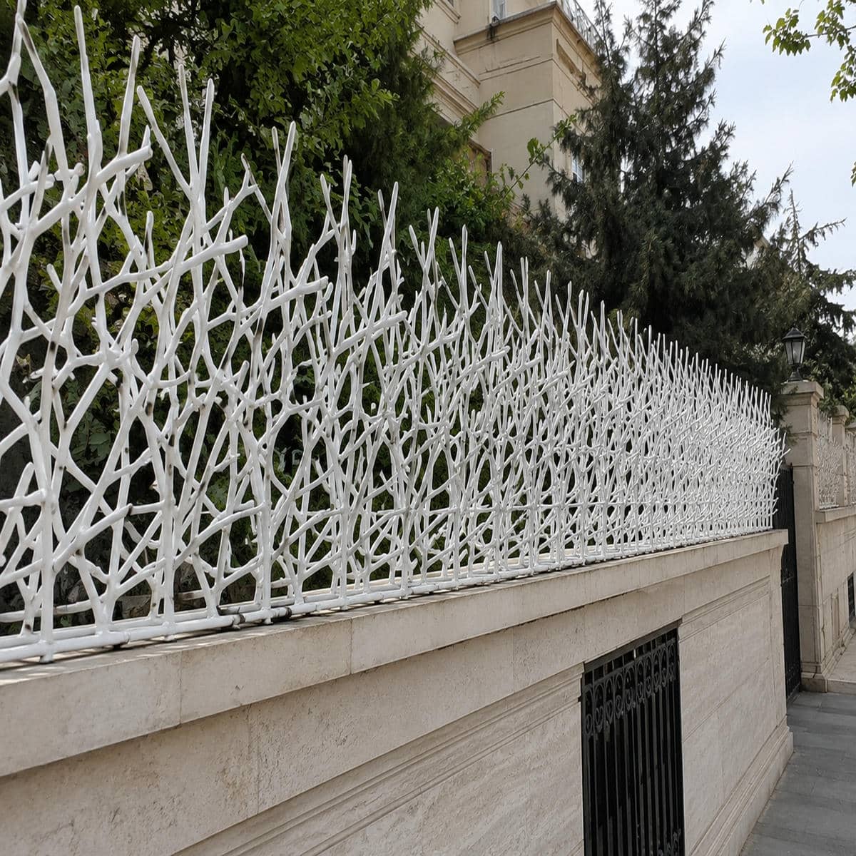 حفاظ دیوار فرفورژه مشکی بر فراز نمای سنگی شهرکرد