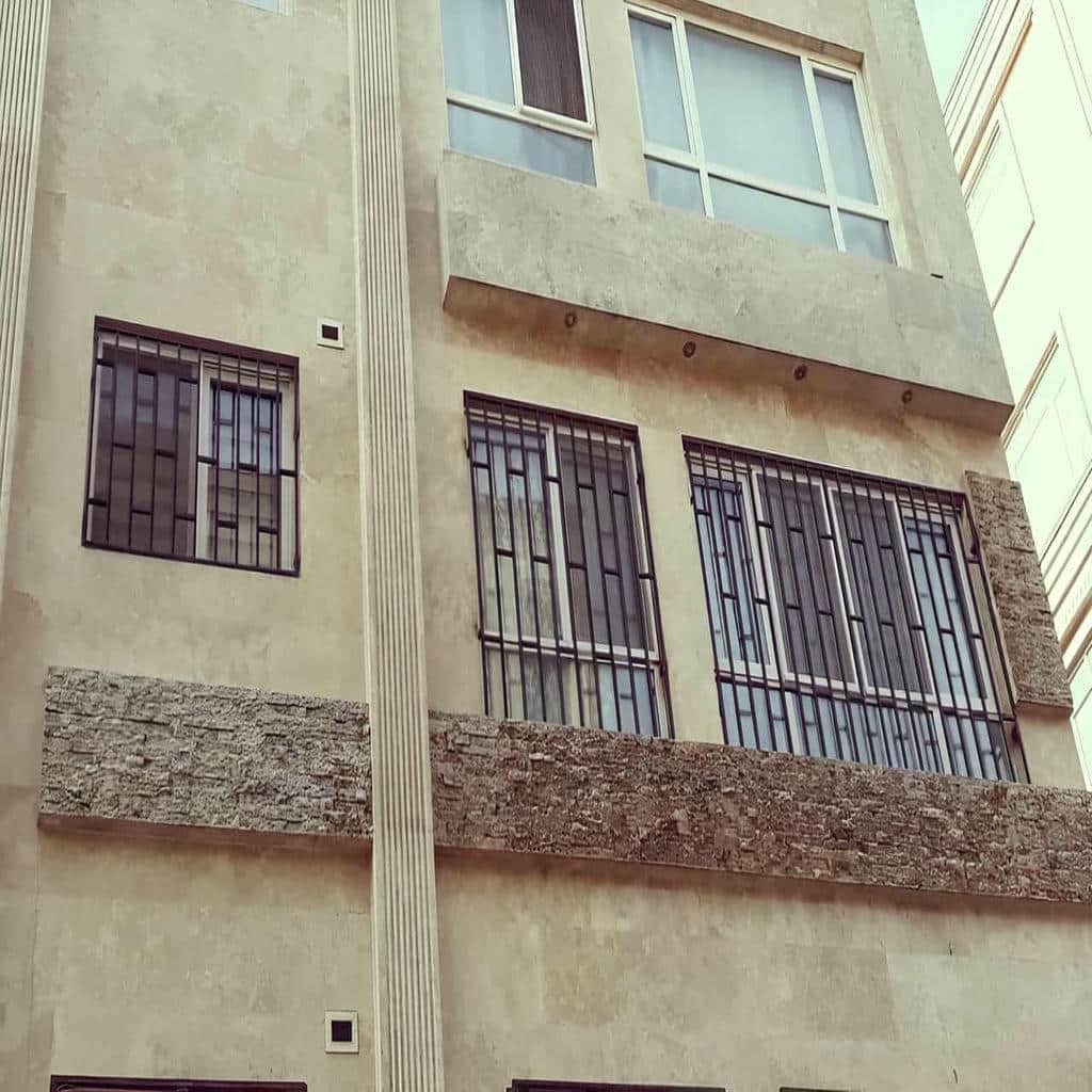 حفاظ پنجره با خطوط عمودی روی دیوار آجری