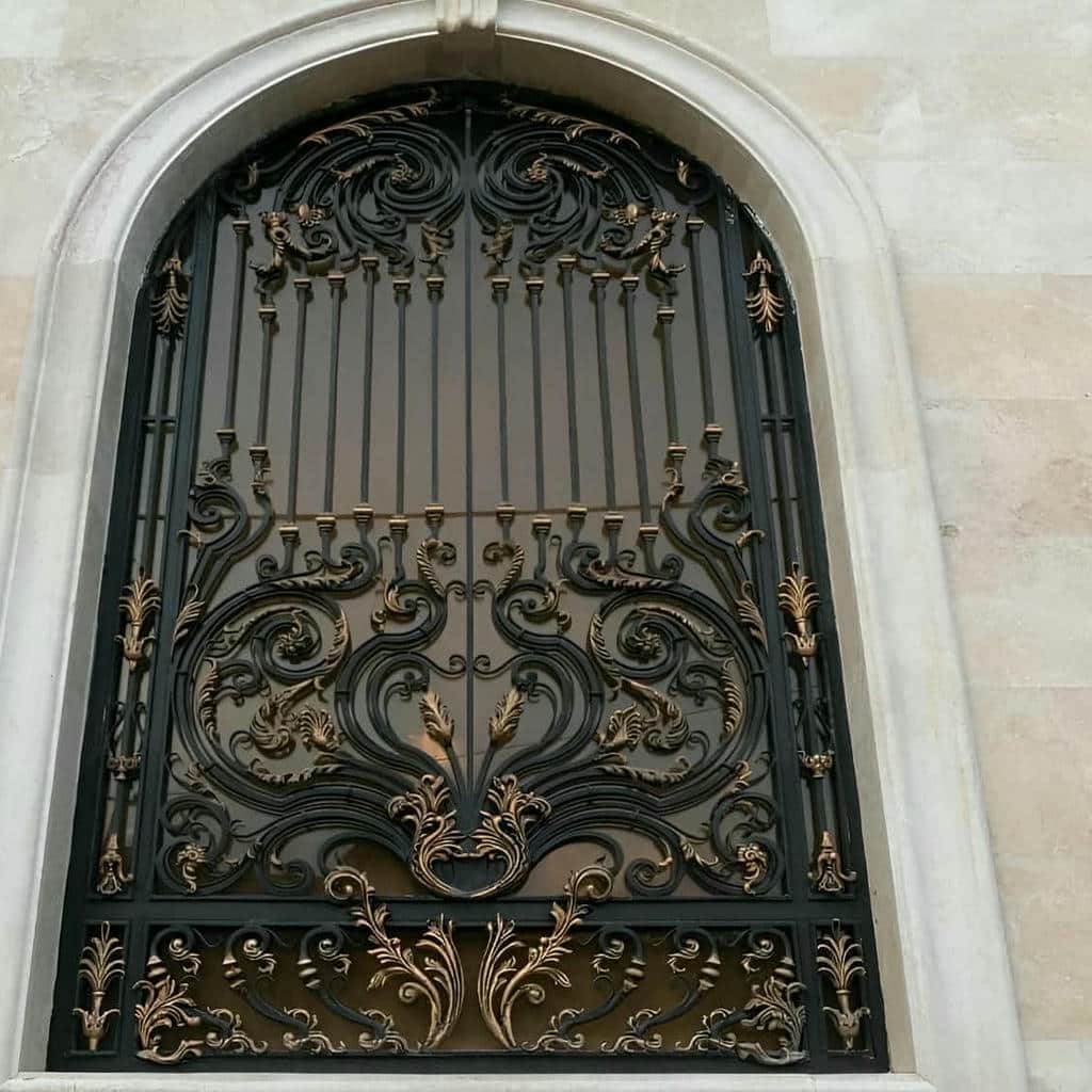 نرده پنجره مشکی روی نمای سنگی آفتاب‌گیر